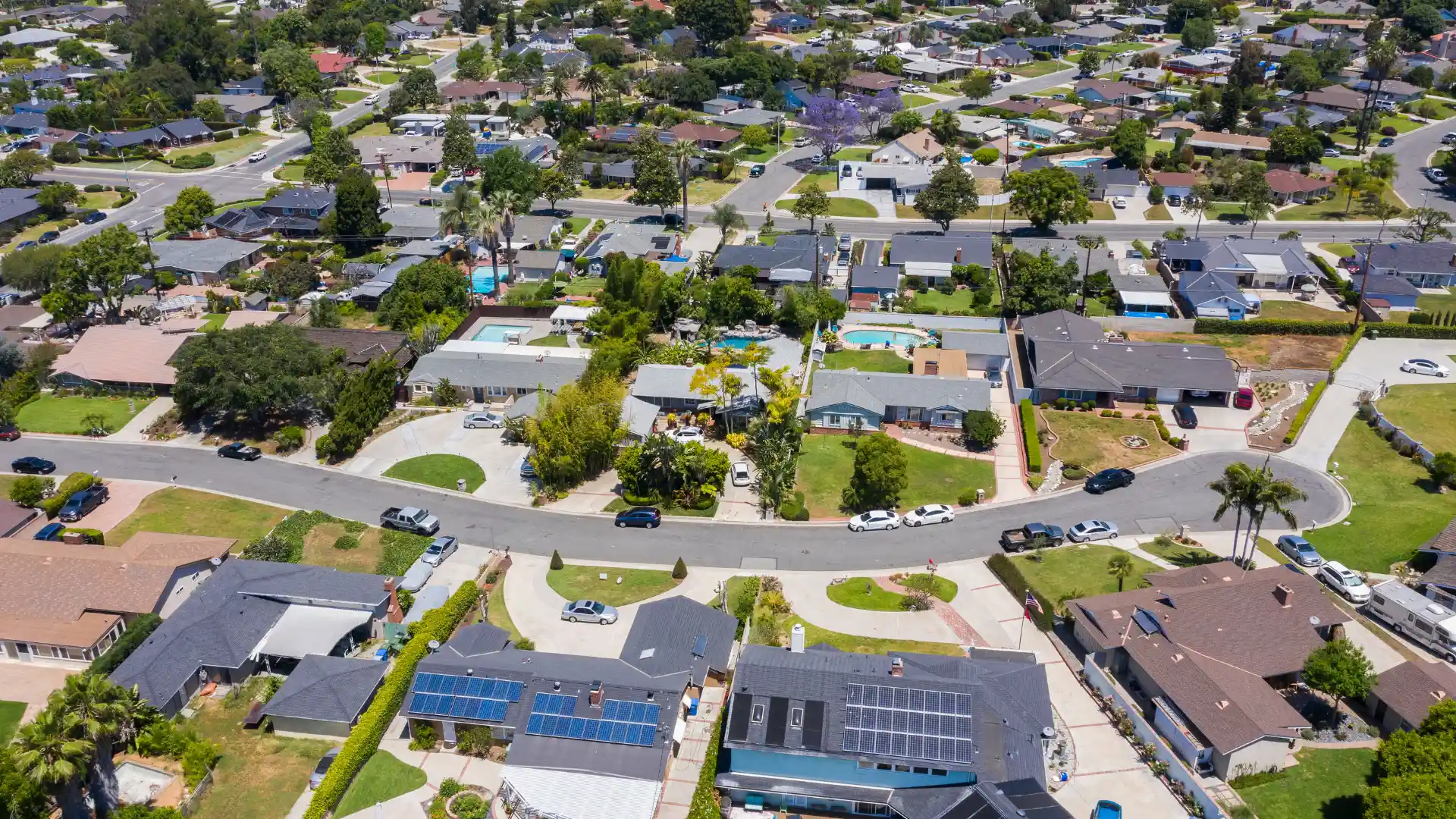 Aerial view of a suburban neighborhood showcasing houses, streets, and green spaces.
